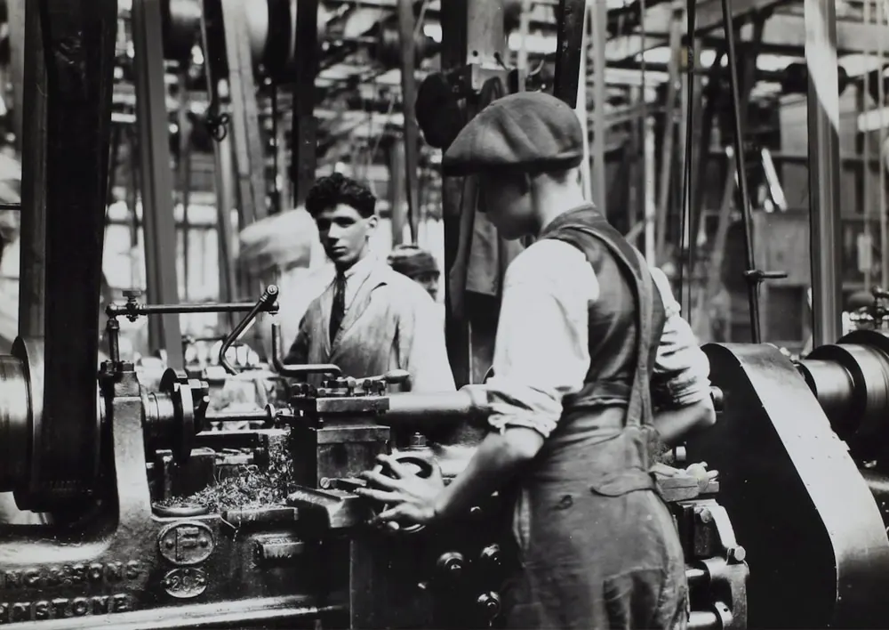 Archival photograph of machinists at work in an early factory