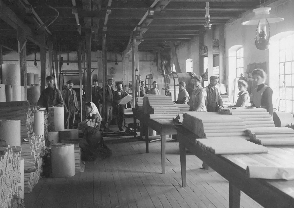 Archival photograph of a busy production hall with workers
